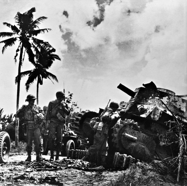 Following their unopposed landing, troops of the US Sixth Army examine a knocked-out Japanese tank of Luzon