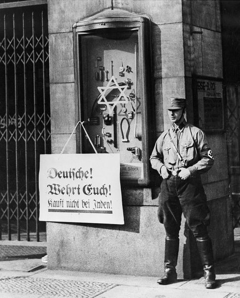 The reality of Nazi power: an SA man stands outside a Jewish shop in Berlin as the boycott of Jewish businesses begins.