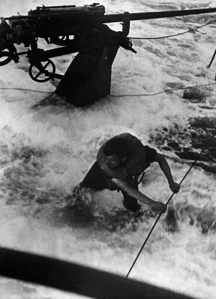 A German sailor struggles to keep his footing on a U-boat during an opeartion in the Atlantic Ocean
