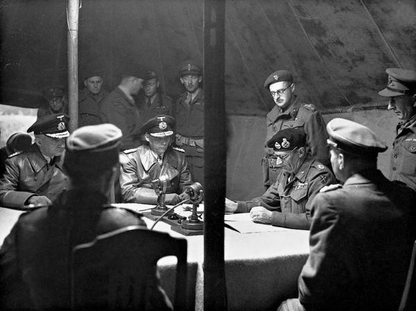 A grim-faced Admiral Hans von Friedeburg and Field Marshal Bernard Montgomery finialize the German surrender